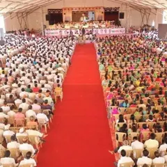 A view from the back of a political rally, showing the massive crowd and the long central aisle. Our team handles the entire layout and seating arrangement to ensure crowd management and visibility for all attendees.