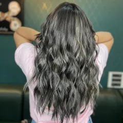 The back view of the ash grey transformation, showing the beautiful blend of grey and silver tones throughout the long, wavy hair.