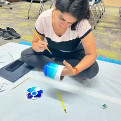 A guest painting a vase she created. Our combo workshop includes both handbuilding with clay and painting your finished piece.