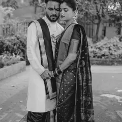 A powerful black and white image of a couple in traditional Maharashtrian attire. The quiet, respectful pose and the monochrome tones give this portrait a solemn and timeless beauty.