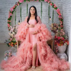 Our popular pink ruffled gown set against a beautiful floral arch. This setup is perfect for a romantic and feminine maternity photoshoot.