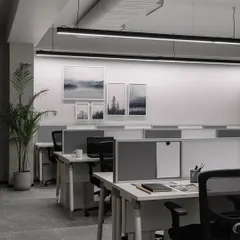 For this pharma office, we designed for productivity with sleek, linear workstations. The space is optimized with pinnable boards, movable storage, and a calming palette of whites and greys, while artwork adds a touch of personality.
