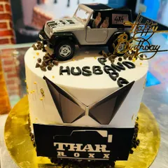 Another awesome Mahindra Thar cake, this time for a husband's birthday. The design features a silver Thar model, chocolate chip details, and the iconic logo.