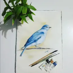 A beautiful bluebird painted in watercolor, shown with the tools of my trade. This nature study showcases my ability to capture delicate details and vibrant color with this medium.