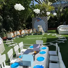 The white and gold train as part of a larger outdoor party setup. This view shows how the train track can be integrated with kids' seating areas and other decorations.