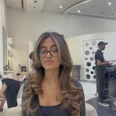 A front-facing view of the same subtle brunette refresh. You can see how the gentle highlights brighten her features, and the soft curls at the ends add volume and movement.