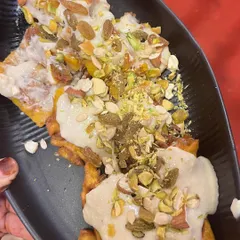 Our Special Dryfruit Malpua with Rabdi. These fluffy, sweet pancakes are soaked in syrup and topped with a generous amount of rich, creamy rabdi and a variety of chopped nuts.