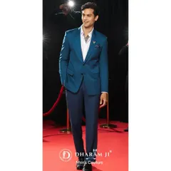 A model wearing a vibrant teal suit on a red carpet. This demonstrates how a well-tailored suit in a bold color can make a powerful style statement.
