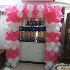 A pink and white balloon gate arch, perfect for welcoming guests or framing a cake-cutting area in a home party setting in Seawoods, Navi Mumbai.
