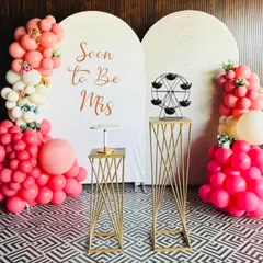 A beautiful setup for a bridal shower. The "Soon to Be Mrs" backdrop is paired with modern white panels, elegant props, and a lovely arrangement of pink and white balloons.