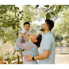 Using the natural frame of tree leaves, this shot captures a mother lifting her baby up to his father. The genuine smiles and beautiful greenery make for a perfect candid family moment.