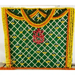 A beautiful backdrop for a traditional function, made with a green panel, marigold garlands, and a central Ganesha motif created from flowers.