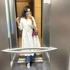 An elevator mirror selfie capturing the details of a comfortable yet chic ethnic look. This combination is perfect for a long day of workshops or client consultations.