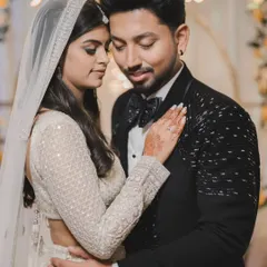 An intimate portrait of a couple in elegant evening wear. The soft, warm lighting and their close embrace create a feeling of romance and sophistication.