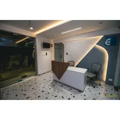 Our reception area features a custom-designed desk and a textured accent wall with dynamic lighting. The terrazzo flooring adds a playful yet sophisticated touch to the space.