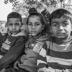 This group of friends sitting on a bench has such a classic, timeless feel in black and white. Their serious expressions and direct eye contact create a very engaging group portrait.