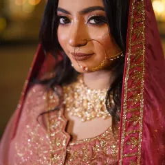 A classic bridal portrait focusing on her exquisite details. The soft lighting beautifully illuminates her makeup, the intricate nose ring, and the sparkle of her jewelry.
