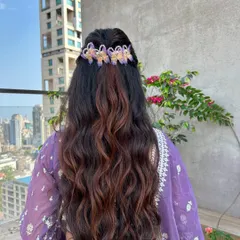 A view from the back showing the detail of the half-up style and the beautiful butterfly hair accessories. The waves are defined yet soft, creating a romantic feel.