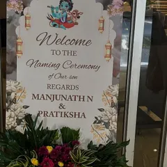 A personalized welcome sign for a naming ceremony, featuring traditional motifs like Lord Krishna to bless the occasion.