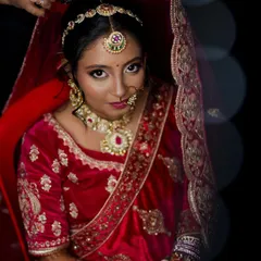 A classic bridal portrait of a Marwadi bride. We use dramatic lighting to accentuate the rich red velvet of her lehenga and the intricate details of her jewelry as she gets ready.