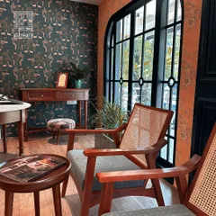 A view of my showroom, where clients can explore pairings of elegant wallpapers, custom-made furniture like these cane-back chairs, and curated decor.