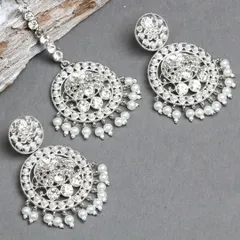 I believe in art from design to photoshoot. This silver-plated earring and maang tikka set is studded with sparkling stones and pearls, creating a look of pure glamour.