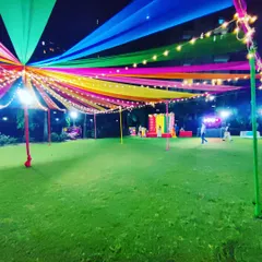 A wide-angle view of the Dandiya night venue. This shot shows the scale of our work, with the expansive fabric canopy covering a large section of the lawn and a decorated stage visible in the background.
