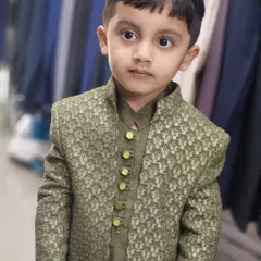 A close-up of our little client looking adorable in his custom-made olive green Indo-Western outfit. I take immense pleasure in getting the youngest members of the family ready for the big day.