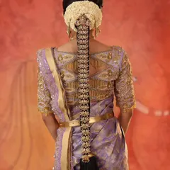 The back view of the ensemble, highlighting the detailed geometric embroidery on the blouse that complements the traditional hairstyle.
