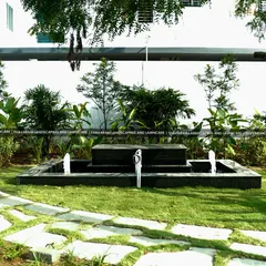 A modern, multi-tiered water fountain crafted from black stone, providing a gentle, soothing sound and a sophisticated centerpiece for this garden.