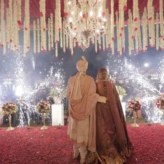 The couple stands on a petal-strewn stage for their varmala ceremony, surrounded by a spectacular display of cold pyrotechnics. I orchestrate these key moments to be as dramatic and memorable as possible.
