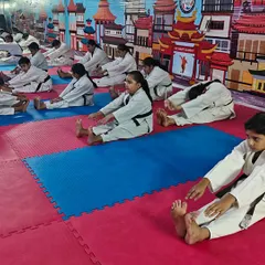 A group of our students performing a seated forward bend stretch together. Group stretching helps with motivation and ensures proper warm-downs after a tough session.