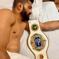 The peace that comes after the battle is won. A champion resting with his title belt after a hard-fought victory.