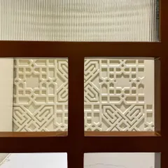 A close-up of the details on the mandir door. We combined fluted glass with a wooden frame and a delicate CNC-cut jali panel, adding layers of texture and craftsmanship.