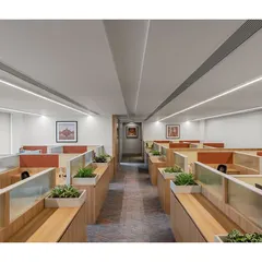 These custom workstations for the IHCL head office, 'The Office with A View', feature an oak laminate base and integrated planters. The design prioritizes a light, airy feel while providing functional elements like writing boards and softboards, enhancing the open-plan office environment.