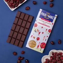 A 70% dark chocolate with cranberries bar, with the ingredients scattered around to visually communicate the flavor.