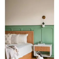A playful yet chic bedroom designed for a young girl. We created a custom fluted wood headboard and a matching bedside table, set against a bold green paneled wall. The cute dog is not part of the design, but certainly adds to the charm!