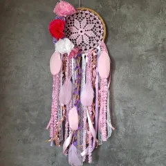 We love playing with color. This pink and red floral dreamcatcher uses bold pom-poms and soft feathers to create a vibrant and unique piece of boho home decor.