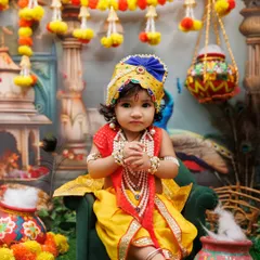 A serene portrait of a baby dressed as little Krishna, sitting peacefully in a vibrant, festive setup.