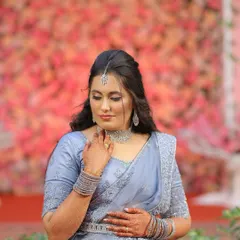 A portrait of elegance for her reception. This look features soft, shimmery eyeshadow, a defined winged liner, and a mauve lip, all coordinated with her beautiful pastel blue lehenga and diamond accessories.