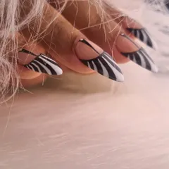 A bold and graphic design featuring sharp, stiletto nails with a modern take on zebra print. The negative space and clean lines give this classic pattern a contemporary and edgy feel.