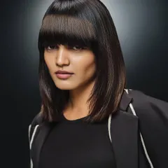 A sleek and polished headshot for a hair campaign. The makeup is clean, minimal, and sophisticated, with a focus on flawless skin and a neutral palette to complement the sharp, modern haircut.