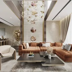 Inside one of our farmhouse projects, this double-height living space is designed for both grand entertaining and intimate family life. The room features a custom tan L-shaped sofa, elegant Italian chairs, and a striking wall clad in beige marble, all illuminated by a bespoke crystal chandelier.