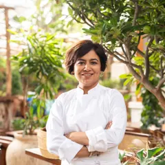 A confident, environmental portrait of the head chef at Bawri India. Posed in her element with natural light and greenery, this shot establishes her as the creative force behind the restaurant's menu.