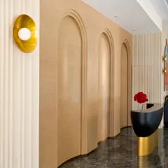 I love playing with architectural shapes to guide the eye and create flow. In this hallway, a series of curved, arched doorways adds a soft, organic feel, contrasting with the sleek marble floor. A simple, elegant brass wall sconce provides warm, ambient light.