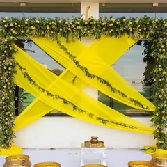 A fresh and traditional Haldi decor. The bright yellow drapes are perfectly complemented by a frame of real greenery and lemons for a zesty touch.