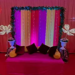A closer look at the Mehendi seating area. We used a bright pink sofa against a colorful backdrop, framed with greenery and fairy lights, creating a perfect spot for the bride.