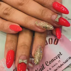 Cute and glamorous, this set features bright red almond nails with a gold glitter accent. The look is completed with adorable 3D rhinestone bows placed at the base of two nails.