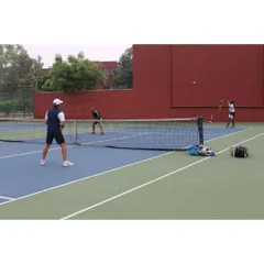 Players engaged in a doubles match, showcasing the ample space and clear markings of our hard courts. We ensure the entire playing area is maintained to professional standards.