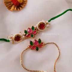 This matching set features a stunning pink and green lotus design. The bhai rakhi is on a traditional thread, while the bhabhi's Lumba is a chic, adjustable gold-plated bracelet she can wear again.